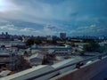 Sky clouds blue lights houses roofs next to highway drive travel commute from airport to city centre kuala lumpur asia