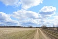 Sky, clouds. Boundless field. Rural road. Forest in the distance. Rural view of nature