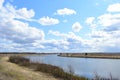 Sky, clouds. Meandering river. Shrubs, grasses on the low banks of the river. Forest in the distance. Rural view Royalty Free Stock Photo