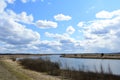 Sky, clouds. Meandering river. Trees, shrubs, grasses on the low banks of the river. Forest in the distance. Rural view Royalty Free Stock Photo