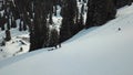 Sky in the clouds overlooking the snow-capped peaks of the mountains.Two travelers with dogs climb the snowy mountains among the s Royalty Free Stock Photo