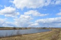 Sky, clouds. River. Boundless field. In the distance, the forest and the village. Rural view of nature Royalty Free Stock Photo