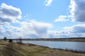 Sky, clouds. The river flows. Boundless field. Forest in the distance. Rural view of nature