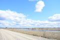 Sky, clouds. Road to the village. River. Fields of young grass. Agricultural