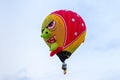 In the sky a hot air balloon in the shape of an angry grandmother at the hot air balloon festival