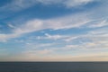 Sky line on the horizon out at sea with a beautiful blue sky with soft wispy clouds