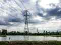 The sky is overcast, it will rain, high voltage pole in the middle of the field. and reservoirs