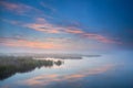 Sky reflected in lake at misty morning