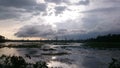 Sky reflecting in the water of the lake at evening. Sun Shines bright through the Clouds. Royalty Free Stock Photo