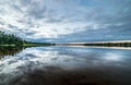 Sky reflection on the blank water surface just before sunset with dark clouds swedish countryside Royalty Free Stock Photo