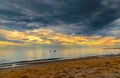 Three brave swimmers under the dark blue stormy sky