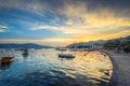 The sky at sunset reflects in the mother-of-pearl water surface, on which lonely boats wander.