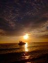 sky sunset sun sea boat water orange shadow beautiful beach golden swimming Royalty Free Stock Photo