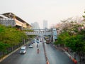 Sky train station, traffic and tabebuia rosea trees along the ro