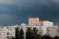 The sky is very dark blue over multi storey buildings before a thunderstorm