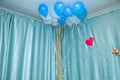 Sky and white balloons float on the white ceiling in the room for the party. Sky and white or children birthday party decoration