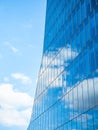 the sky with white clouds reflecting in the glass windows of a modern office building Royalty Free Stock Photo