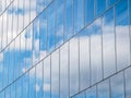 The sky with white clouds reflecting in the glass windows of a modern office building Royalty Free Stock Photo