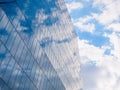 The sky with white clouds reflecting in the glass windows of a modern office building Royalty Free Stock Photo