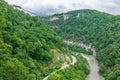 Skybridge suspension bridge over a gorge over an abyss with a river and serpentine road. Skypark, Sochi, Russia