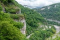 Skybridge suspension bridge over a gorge over an abyss with a river and serpentine road. Skypark, Sochi, Russia