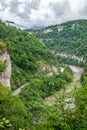 Skybridge suspension bridge over a gorge over an abyss with a river and serpentine road. Skypark, Sochi, Russia