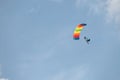 Skydiver on a rainbow colored para sail.