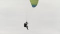 Skydiver is going to land and finish his flight. Action. Bottom view of a landing parachutist with a cloudy heavy sky on Royalty Free Stock Photo