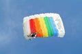 Parachuter, skydiver jumping and skydiving with colorful parachute in rainbow colours on parachuting cup, extreme sport