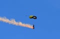 Skydiver with a smoke trail against blue sky Royalty Free Stock Photo