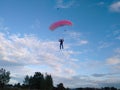 A skydiver with a sports parachute wing flies before landing in the summer Royalty Free Stock Photo