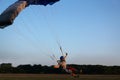 Skydiver under a dark blue and grey little canopy of a parachute