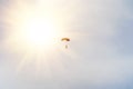 Skydiver under little canopy of a parachute on the background a sun and a blue sky. Silhouette of the skydiver with parachute Royalty Free Stock Photo