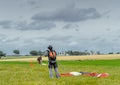 Skydiver unfasten his parachute after landing.