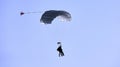 A skydiver with a white parachute canopy against a blue sky and white clouds, close-up Royalty Free Stock Photo