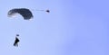 A skydiver with a white parachute canopy against a blue sky and white clouds, close-up Royalty Free Stock Photo