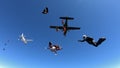 Skydivers jump out of tow airplanes with blue skies.