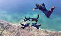 Skydiving formation with videoman over sea