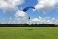 Skydiving. A girl is landing on the green field. Royalty Free Stock Photo