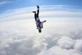 Skydiving. Skydiver in head down position is falling above clouds.
