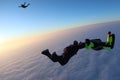 Skydiving. Sunset jump. Skydivers are above pink clouds.