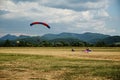Skydiving, tandem parachutists in the sky and two parachutist on the ground Royalty Free Stock Photo