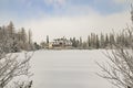 Skying resort hotel apartments building winter time forest landscape near frozen lake peaceful outdoor scenic view Royalty Free Stock Photo