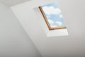 Skylight roof window and lamps on slanted ceiling in attic room, low angle view Royalty Free Stock Photo