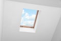 Skylight roof window and lamps on slanted ceiling in attic room, low angle view Royalty Free Stock Photo