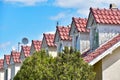 Row of multiple roof windows with red tiles and rustic white wooden walls Royalty Free Stock Photo