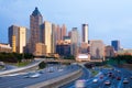 Skyline of Atlanta at sunset with traffic in the freeway