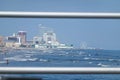 Skyline of Atlantic City from a distance over the rough ocean seen between metal rails of a fence Royalty Free Stock Photo