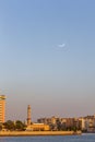 Skyline of Deira, Dubai during sunset with Dubai Creek, mosque minaret and crescent moon in the sky. Royalty Free Stock Photo