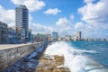 The skyline of Havana with waves crashing on the seawall